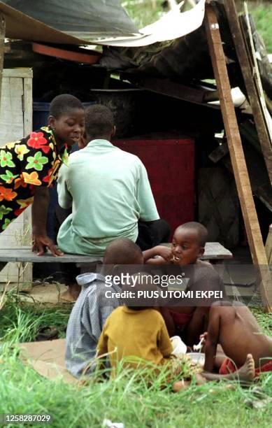 Children eat their breakfast in front of their demolished building 23 May 2001 in a Lagos slum. Several thousands of people were rendered homeless as...