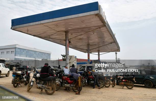 Motorbike taxis and motorists queue to buy fuel out of stock at a petrol station at Warewa, Ogun State in southwest Nigeria, on May 30, 2023. Queues...