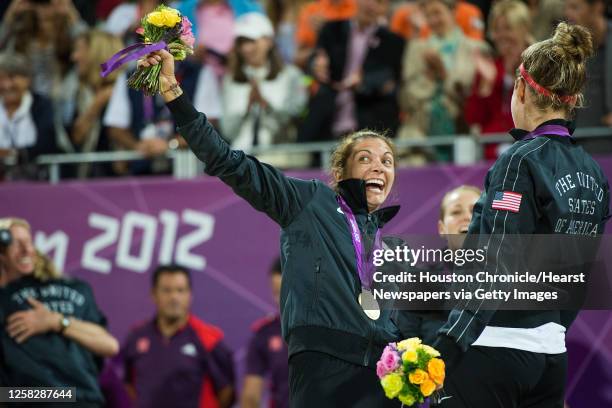 Jennifer Kessy, left, and April Ross, right, celebrate with their silver medals on the podium after the women's beach volleyball gold medal match at...