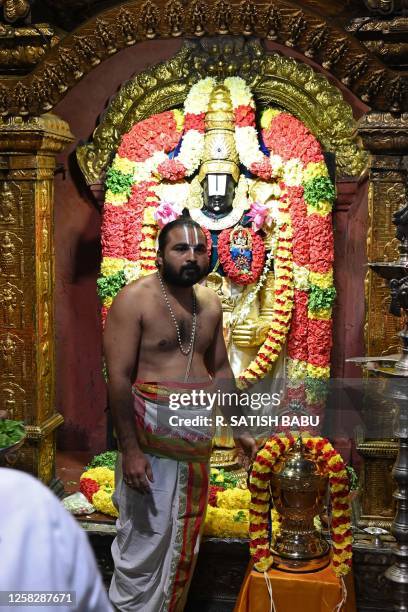Priest stands next to the Indian Premier League 2023 trophy placed inside a temple by the Chennai Super Kings team management to seek blessings,...