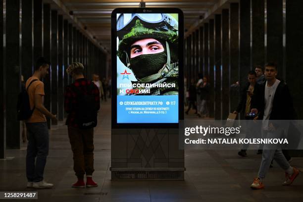 An advertising screen promoting contract military service in the Russian army sits on a metro station platform in Moscow on May 30, 2023.