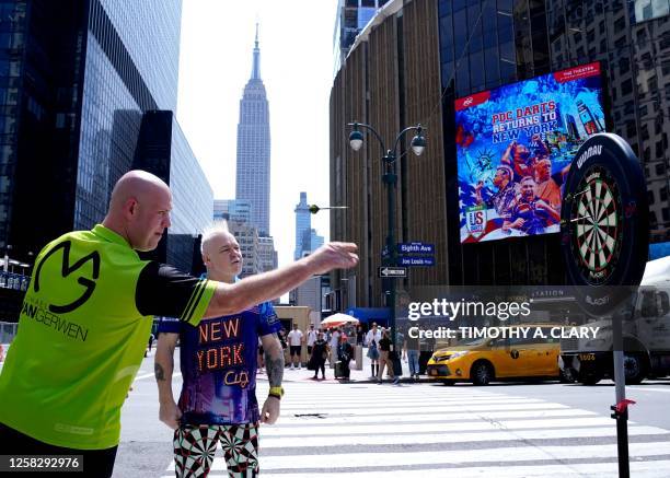 Dutch professional darts player Michael "Mighty Mike" van Gerwen and Scottish professional darts player Peter "Snakebite" Wright play darts outside...