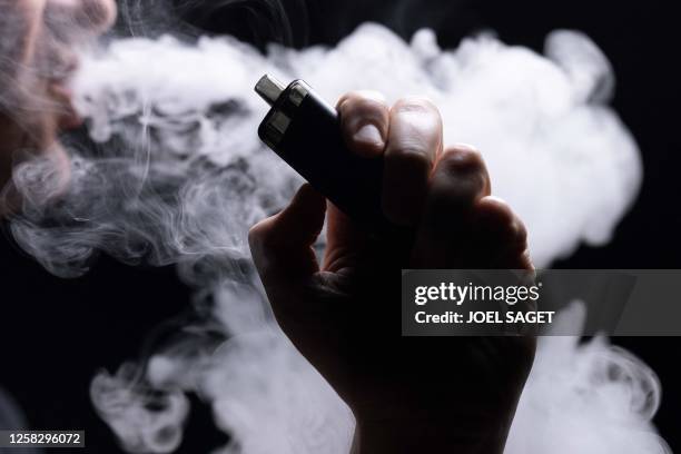 This photograph taken on May 30, 2023 show an individual vaping an electronic cigarette in Paris.