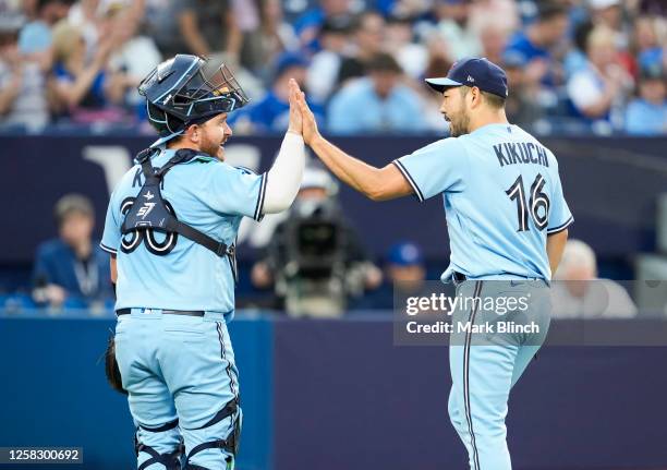 Yusei Kikuchi of the Toronto Blue Jays celebrates with Alejandro Kirk after the fourth inning where he recorded his 500th career strikeout against...