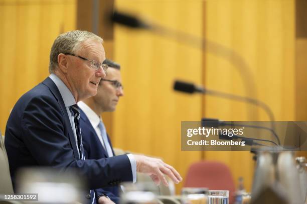 Philip Lowe, governor of the Reserve Bank of Australia , left, speaks during the Senate economics committee hearing at Parliament House in Canberra,...