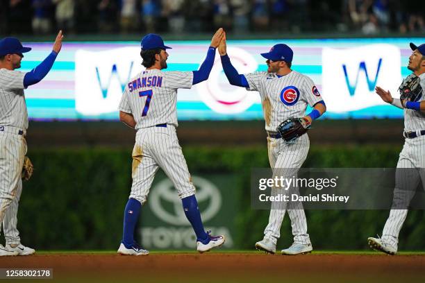 Nico Hoerner of the Chicago Cubs high-fives teammate Dansby Swanson after the game between the Tampa Bay Rays and the Chicago Cubs at Wrigley Field...