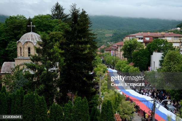 Hundreds of ethnic Serbs carry a giant Serbian flag through the town of Zvecan, in northern Kosovo, on May 31, 2023. Tensions remained high after...