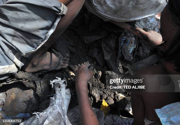 Residents gather scrap metal dumped by a bus company in the outskirts of Central Philippines' city of Bacolod on February 9, 2011. Poverty worsened...