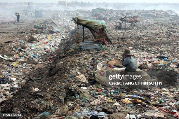 Cambodia-economy-labour-poverty-child, by Lucie Lautredou A Cambodian scarvenger sit at a rubbish damp in Phnom Penh on January 4, 2008. Doctor Tuy...