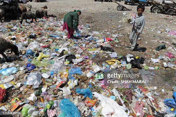 Afghan children scavenge for plastic and metal items at a rubbish dump in Kabul on June 29, 2010. Thousands of children who live on the streets of...