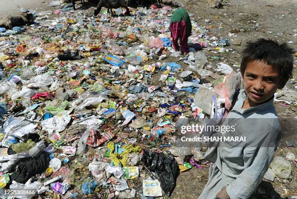 Afghan children scavenge for plastic and metal items at a rubbish dump in Kabul on June 29, 2010. Thousands of children who live on the streets of...