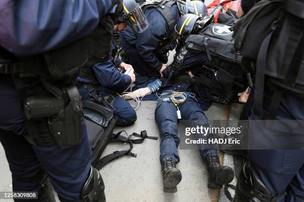 Police targeted during protests against retirement at 64. CRS doctors and Paris fire fighters provides first aid to a 28-year-old policewoman who was...