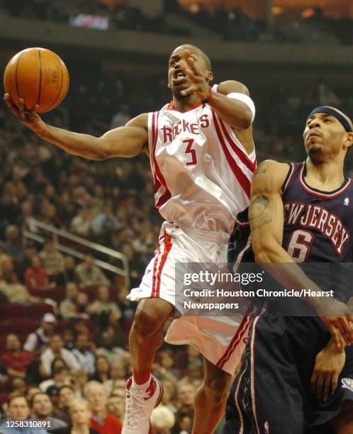 Steve Francis drives to the basket over Net's, Kenyon Martin, in the first half during the Houston Rockets-New Jersey Nets NBA basketball game at...