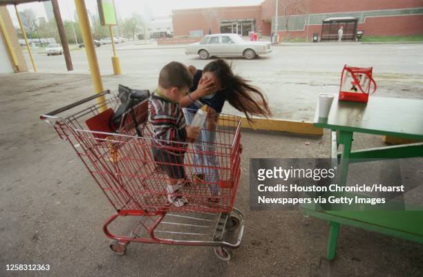Erica Ayala plays hide and go seek, with her nephew, Christopher Villarial, just over 1-year-old, as he stands in a shopping cart in the shade at...