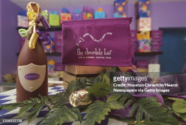 The Chocolate Bar's solid chocolate champagne bottle and foil covered rose sits on the display case of the store, which is being featured in the...