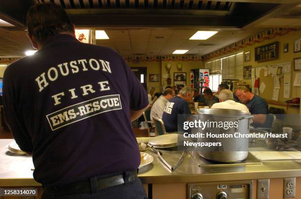 Firefighter and chef Daniel Matt, foreground, serves his famous Beef Tip dinner for hungry firefighters at Houston Fire Department's Station 28, 3100...