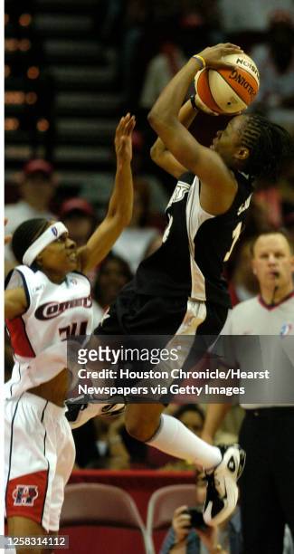 San Antonio's, Shannon Johnson jumps over Houston's, Felicia Ragland on her way to the basket, during the second half of the season opener WNBA game...