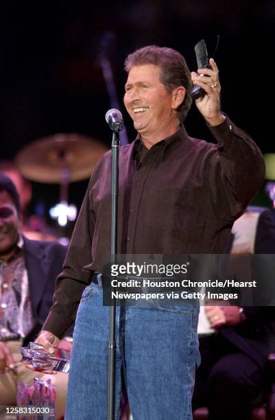 Mac Davis holds up his cell phone, with his mother on the other end of the line as he takes the stage to receive his award before the start of the...