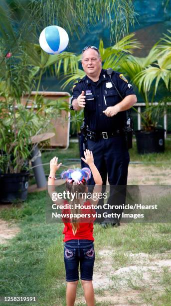 Officer Marte McDowell plays with a beach ball with Alexa Gray during the 2014 Southwest Airlines Freedom over Texas at Eleanor Tinsley and Sam...