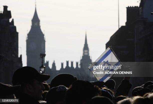 Demonstrator holds aloft an Israeli flag during a rally in Trafalgar Square in London, on January 11, 2009. Thousands of British Jews attended the...