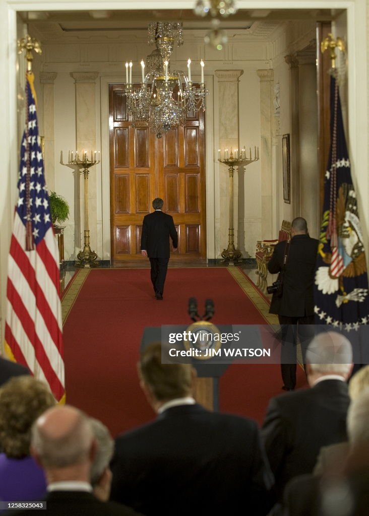US President W. Bush walks down the cross hall as he departs