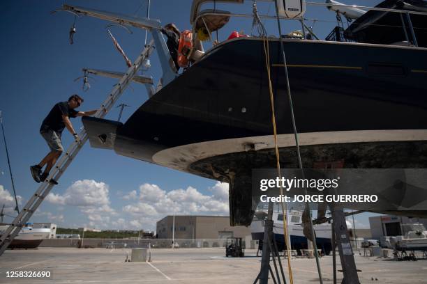 Man goes down the ladder hung on a ship attacked by killer whales while sailing in the Strait of Gibraltar and taken for repairs at the Pecci...