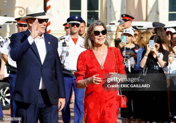 Prince Albert II of Monaco waves, flanked by Princess Caroline of Hanover as they attend celebrations marking the birth of the late Rainer III in...