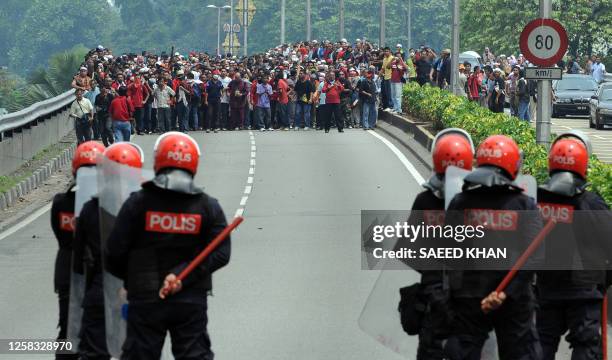 Malaysian anti-riot police prepare to fire tear gas shells to disperse demonstrators near Merdeka Square in Kuala Lumpur on August 1, 2009. Malaysian...