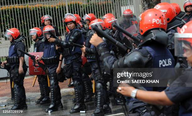 Malaysian anti-riot police prepare to fire tear gas shells to disperse demonstrators near Merdeka Square in Kuala Lumpur on August 1, 2009. Police...