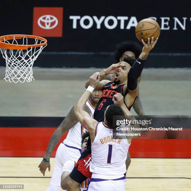 Houston Rockets forward Kenyon Martin Jr. Goes up the basket against Phoenix Suns guard Devin Booker during the first half of an NBA basketball game...