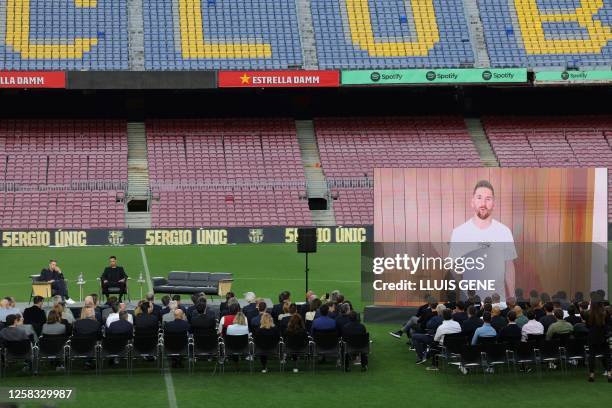 Paris Saint-Germain's Argentine forward Lionel Messi on a giant screen talks during a farewell ceremony for Barcelona FC's Spanish midfielder Sergio...