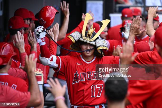 Shohei Ohtani of the Los Angeles Angels celebrates in the dugout after hitting his second two-run home run of the game in the fourth inning against...