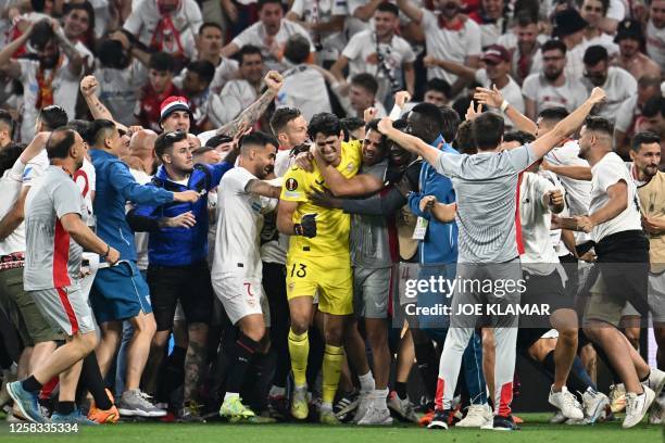 Sevilla's players celebrate with Moroccan goalkeeper Yassine Bounou after winning the penalty shootout of the UEFA Europa League final football match...