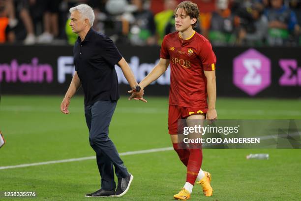 Roma's Portuguese coach Jose Mourinho leads AS Roma's Italian midfielder Edoardo Bove off the pitch after the UEFA Europa League final football match...