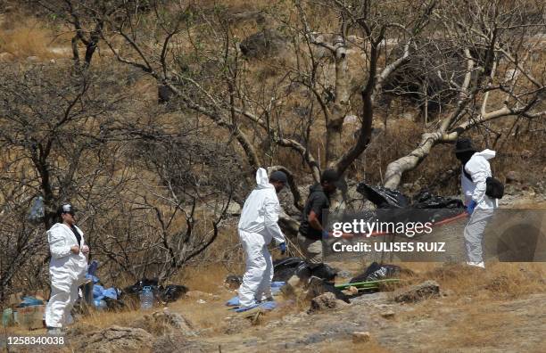 Forensic experts work with several bags of human remains extracted from the bottom of a ravine by a helicopter, which were abandoned at the Mirador...