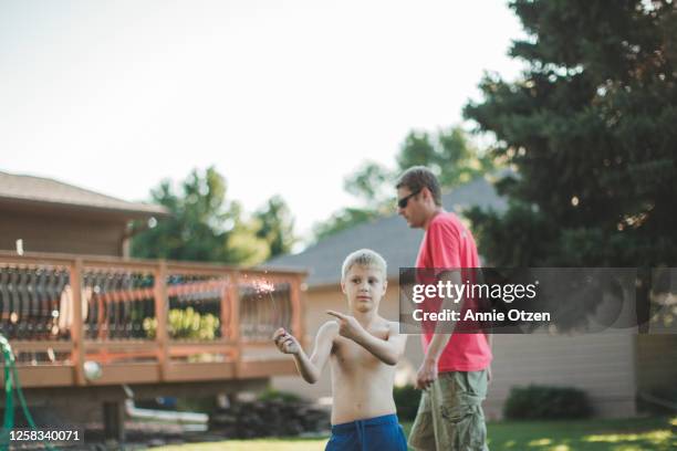 boy holding and pointing to a sparkler - s parks and recreation season 7 stock-fotos und bilder