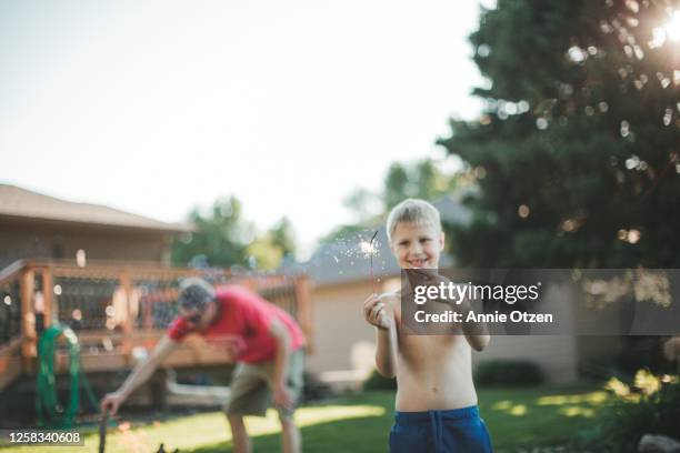 boy holding and pointing to a sparkler - s parks and recreation season 7 stock-fotos und bilder