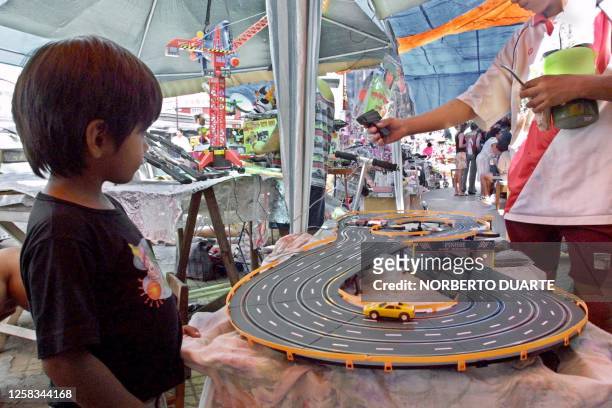 Boy watches a toy car race track at a toy store in Asuncion, Paraguay, 05 January 2001, the traditional day "los Reyes Magos" eve, when children...