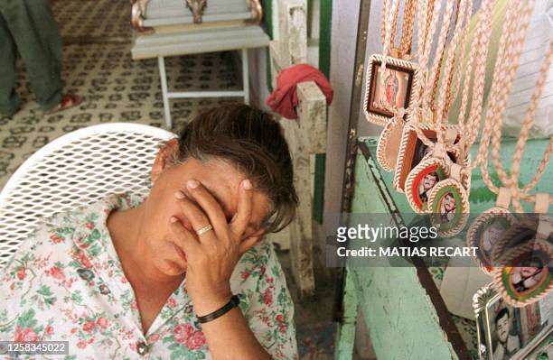 Un mujer vendedora de articulos religiosos descansa 09 julio al lado de figuritas del santo popular Jesus Malverde en la ciudad de Culiacan misma...