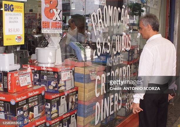 Pedestrian looks at goods in the window of an appliance store in downtown Rio de Janeiro 11 September after Brazil's central bank raised the nation's...