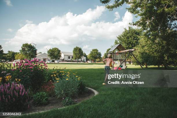 summer boy running across lawn - backyard stock pictures, royalty-free photos & images