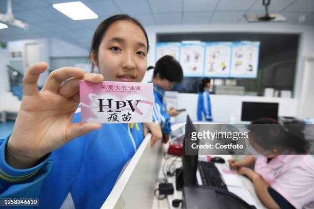 Schoolgirl shows her HPV vaccination card after receiving her first dose of HPV vaccine in Guiyang, Guizhou province, China, June 1, 2023.