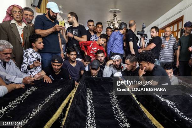 Mourners gather by the coffins of slain members of the Popular Front for the Liberation of Palestine General Command upon their repatriation at...