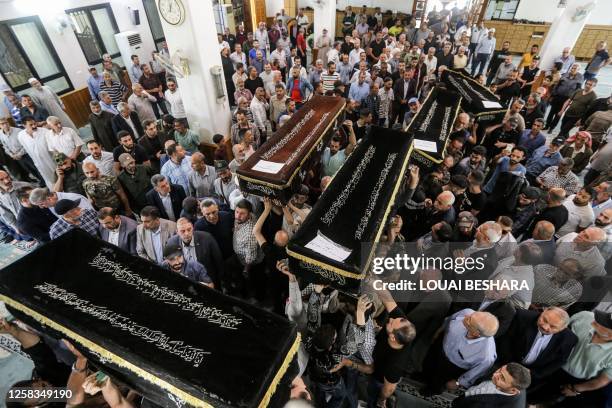 Mourners gather by the coffins of slain members of the Popular Front for the Liberation of Palestine General Command upon their repatriation at...