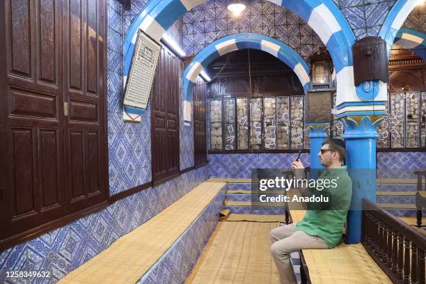 Man takes a photo at Garibe Synagogue, considered one of the oldest Jewish places of worship in Africa in Jerba Island, Tunisia on May 24, 2023. The...