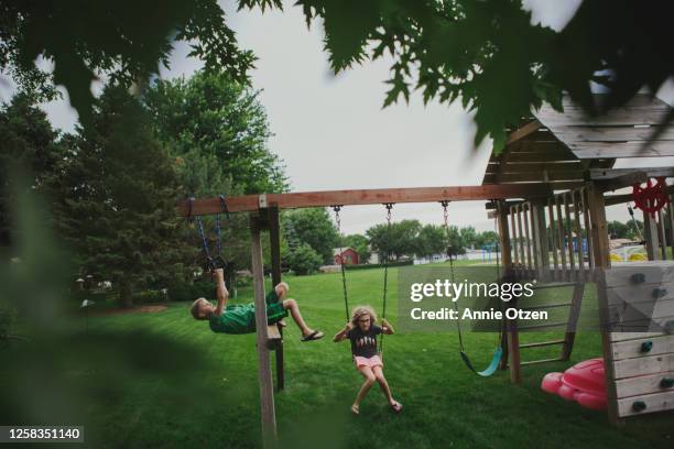 kids playing on backyard swing set - backyard swing set stock pictures, royalty-free photos & images