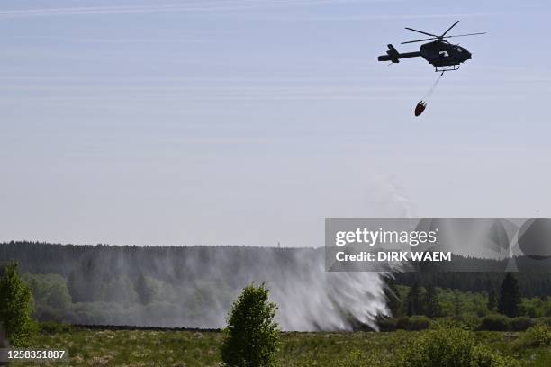 Illustration shows a civil protection helicopter with a special water-dropping bag pictured on the scene of a fire in the Hautes Fagnes between...