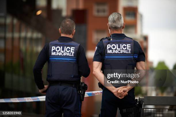 Two pliceman from the municipal police satnd haurd during the protest. Two climbers from XR Toulouse climbed on the facade of the Mediatheque of...