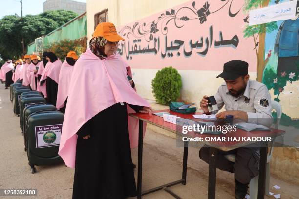 Syrian Muslim pilgrims register for a training session on performing the rituals of Hajj and travel procedures to Mecca in the town of Hazzanu in the...