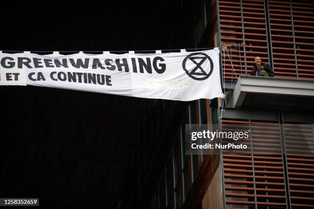 Two climbers from XR Toulouse climbed on the facade of the Mediatheque of Toulouse to put a banner reading ' 0 ambition forum - 100% greenwashing,...